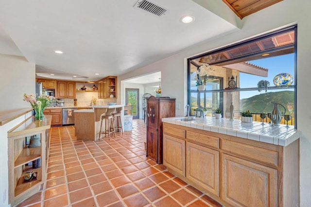 2702 Country Club Dr, Escondido, CA 92029 - kitchen featuring open shelves, stainless steel appliances, a kitchen bar, recessed lighting, and tasteful backsplash