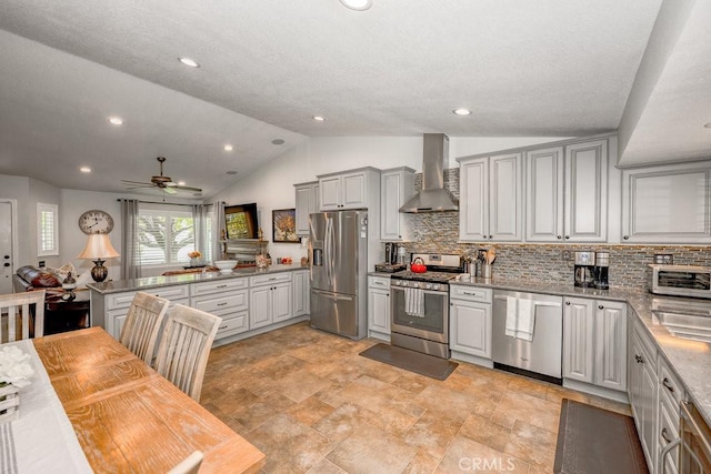 27817 Wakefield Rd, Castaic, CA 91384 - kitchen featuring appliances with stainless steel finishes, wall chimney range hood, vaulted ceiling, decorative backsplash, and ceiling fan