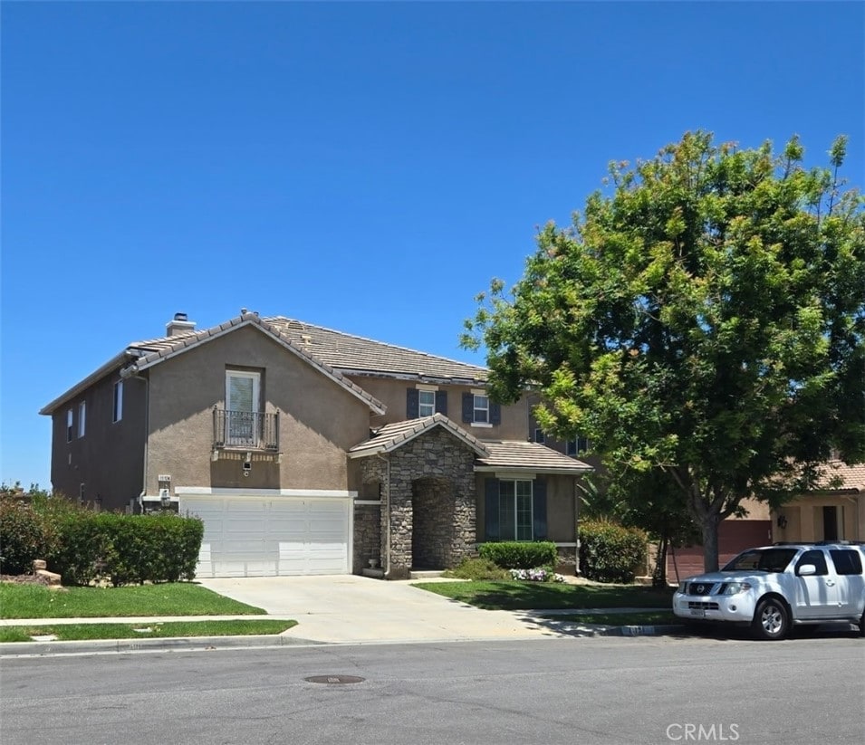 11124 Jasmine Way, Corona, CA 92883 - view of front of home featuring stucco siding, driveway, an attached garage, a tile roof, and stone siding