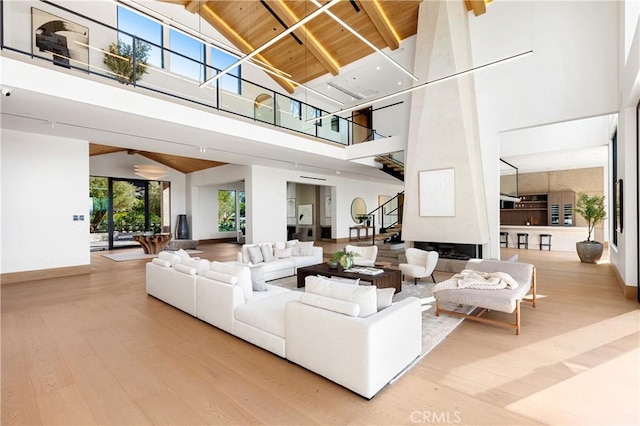 25151 Jim Bridger Rd, Hidden Hills, CA 91302 - living room with high vaulted ceiling, wood finished floors, stairway, and a wooden ceiling with exposed beams