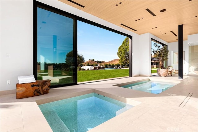 25151 Jim Bridger Rd, Hidden Hills, CA 91302 - outdoor pool with an in-ground hot tub, a patio area, a yard, a ceiling fan, and a mountain view
