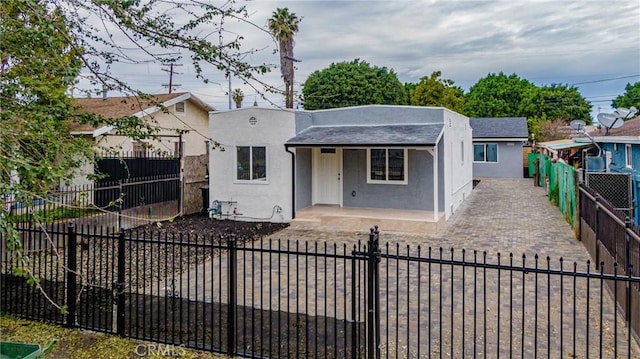 323 E 93rd St, Los Angeles, CA 90003 - bungalow with covered porch, a fenced front yard, roof with shingles, and stucco siding