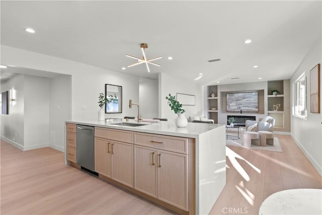12934 Fenton Ave, Sylmar, CA 91342 - kitchen with light wood-style flooring, stainless steel dishwasher, a glass covered fireplace, open floor plan, and recessed lighting
