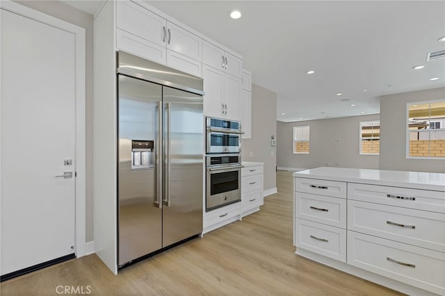 573 Patten Ave, Placentia, CA 92870 - kitchen with stainless steel appliances, white cabinets, light wood-style flooring, light countertops, and recessed lighting