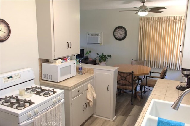 1522 E Broadway, Anaheim, CA 92805 - kitchen featuring white appliances, tile countertops, a wall mounted AC, light wood-type flooring, and ceiling fan