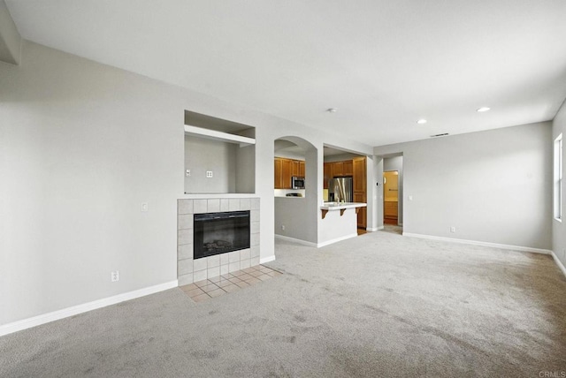 2755 Castlehill Rd Unit 1, Chula Vista, CA 91915 - unfurnished living room featuring light colored carpet, a fireplace, recessed lighting, and arched walkways