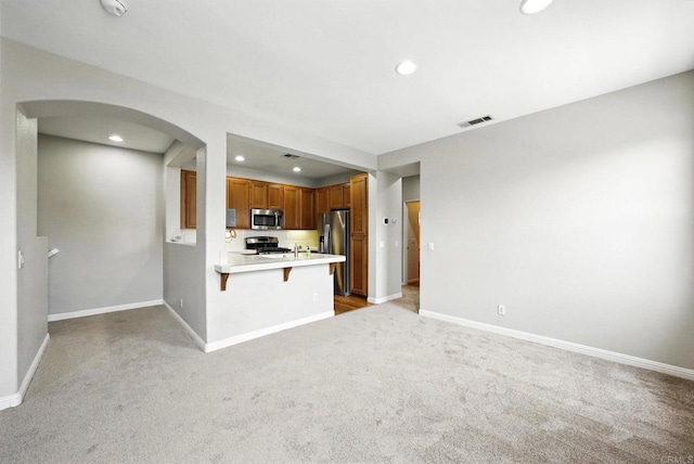 2755 Castlehill Rd Unit 1, Chula Vista, CA 91915 - kitchen with appliances with stainless steel finishes, carpet, a breakfast bar area, open floor plan, and arched walkways