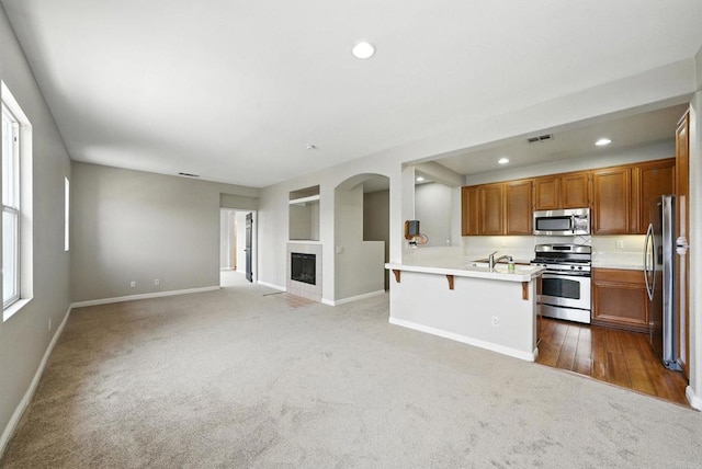 2755 Castlehill Rd Unit 1, Chula Vista, CA 91915 - kitchen with stainless steel appliances, carpet, open floor plan, recessed lighting, and a kitchen bar