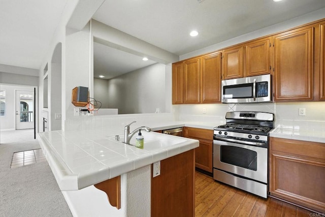 2755 Castlehill Rd Unit 1, Chula Vista, CA 91915 - kitchen featuring appliances with stainless steel finishes, a peninsula, tile countertops, recessed lighting, and brown cabinets