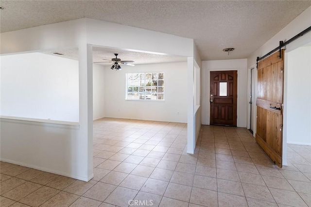 9018 Buckthorn Ave, Hesperia, CA 92345 - entryway featuring a textured ceiling, a barn door, light tile patterned flooring, and ceiling fan