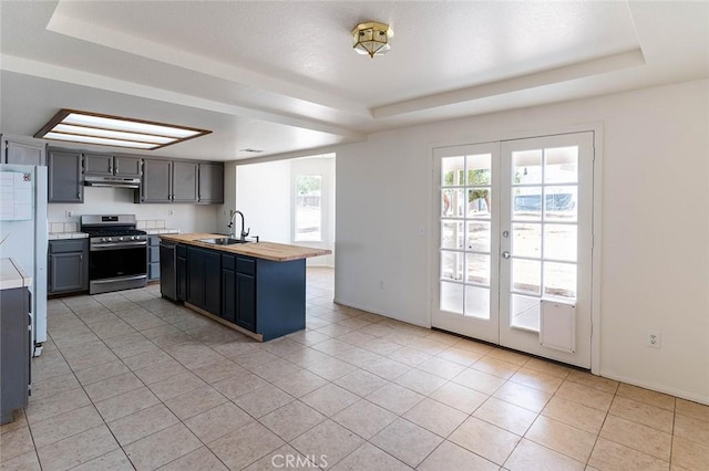 9018 Buckthorn Ave, Hesperia, CA 92345 - kitchen featuring stainless steel gas range oven, a raised ceiling, and butcher block countertops