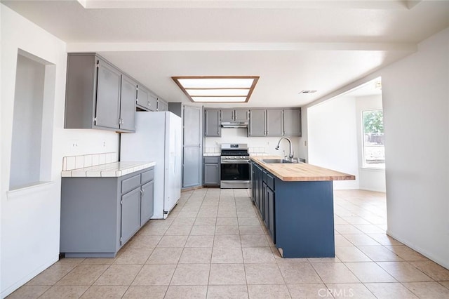 9018 Buckthorn Ave, Hesperia, CA 92345 - kitchen featuring stainless steel range oven, freestanding refrigerator, and gray cabinetry