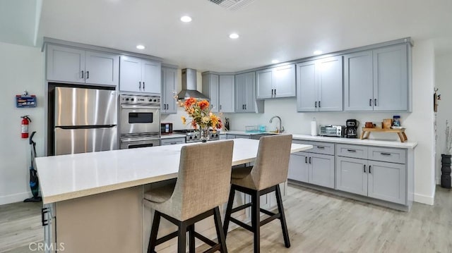10361 Perdido St, Anaheim, CA 92804 - kitchen with wall chimney exhaust hood, appliances with stainless steel finishes, gray cabinets, and recessed lighting