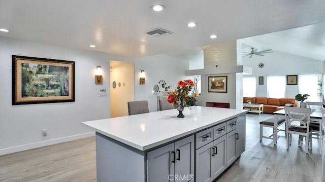 10361 Perdido St, Anaheim, CA 92804 - kitchen with gray cabinets, light wood-type flooring, a center island, a ceiling fan, and light countertops