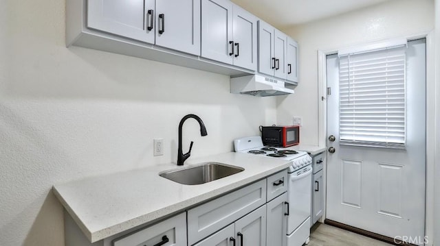 10361 Perdido St, Anaheim, CA 92804 - kitchen with white range with electric cooktop, under cabinet range hood, black microwave, and light stone counters