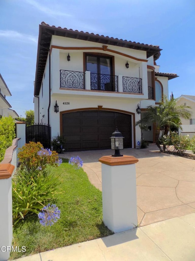 4526 Katherine Ave, Sherman Oaks, CA 91423 - mediterranean / spanish-style home with a balcony, an attached garage, stucco siding, concrete driveway, and a tile roof