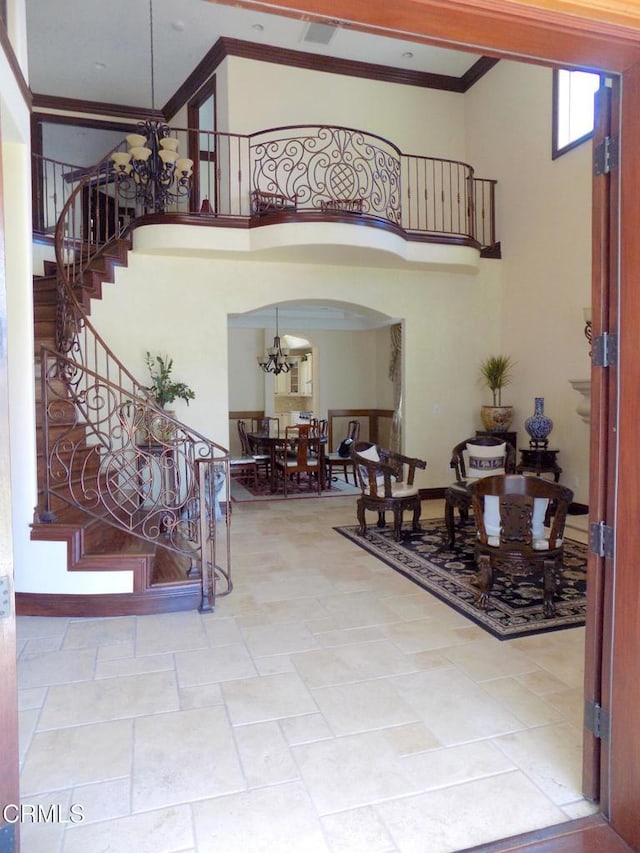 4526 Katherine Ave, Sherman Oaks, CA 91423 - foyer featuring a chandelier, stairway, a towering ceiling, arched walkways, and crown molding