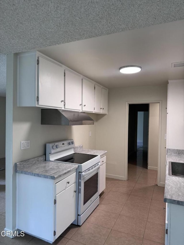 3700 Dean Dr Unit 1301, Ventura, CA 93003 - kitchen featuring white electric stove, under cabinet range hood, white cabinetry, and light tile patterned flooring