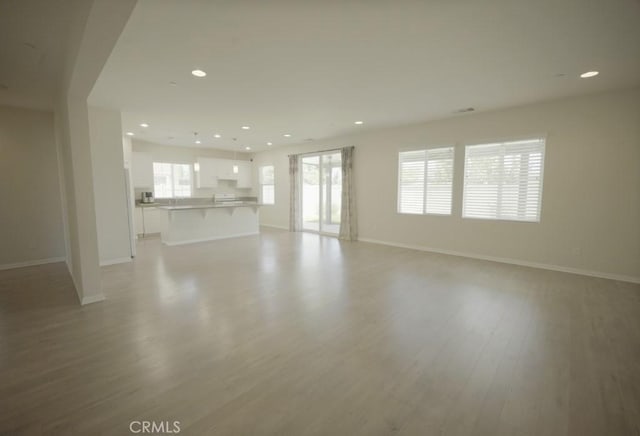 25382 Rocking Horse Ct, Menifee, CA 92584 - unfurnished living room featuring light wood-type flooring and recessed lighting