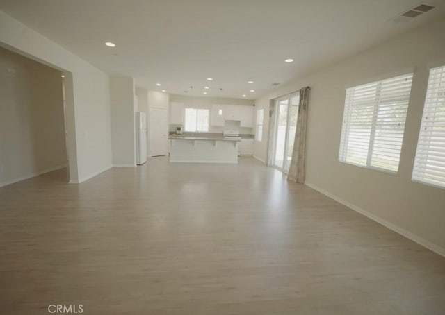 25382 Rocking Horse Ct, Menifee, CA 92584 - unfurnished living room with light wood finished floors and recessed lighting