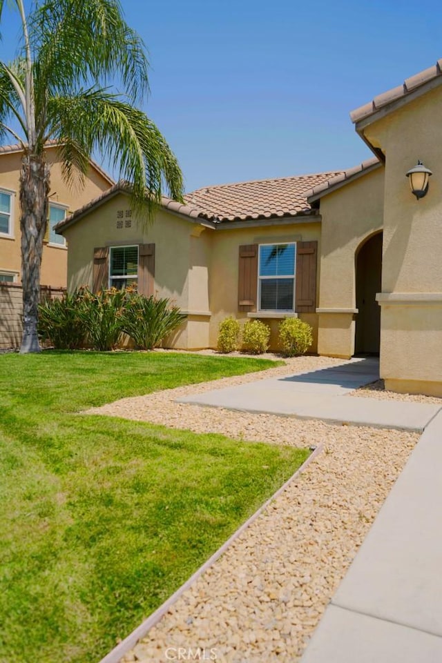 25382 Rocking Horse Ct, Menifee, CA 92584 - mediterranean / spanish house featuring a tiled roof, stucco siding, and a front lawn