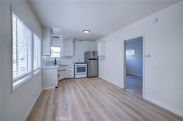 3731 Glendon Ave Unit 1, Los Angeles, CA 90034 - kitchen with white range with gas stovetop, freestanding refrigerator, white cabinets, light wood finished floors, and light countertops