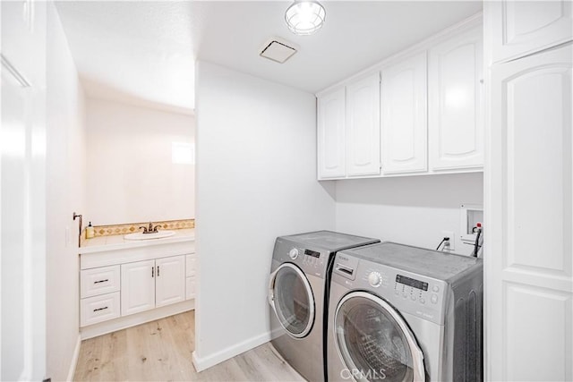 3807 Paula Ln, Lancaster, CA 93535 - washroom with cabinet space, washing machine and dryer, and light wood-type flooring