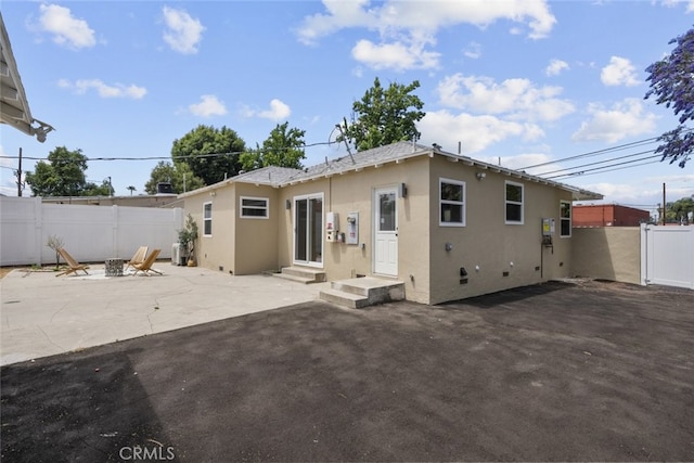 6820 Jellico Ave, Van Nuys, CA 91406 - back of property featuring stucco siding, a patio area, and a fire pit