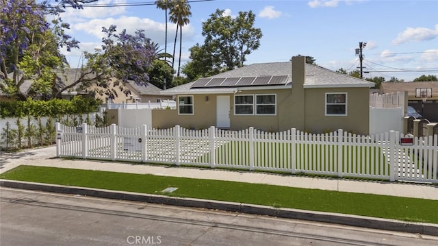 6820 Jellico Ave, Van Nuys, CA 91406 - bungalow with stucco siding, roof mounted solar panels, a shingled roof, and a fenced front yard