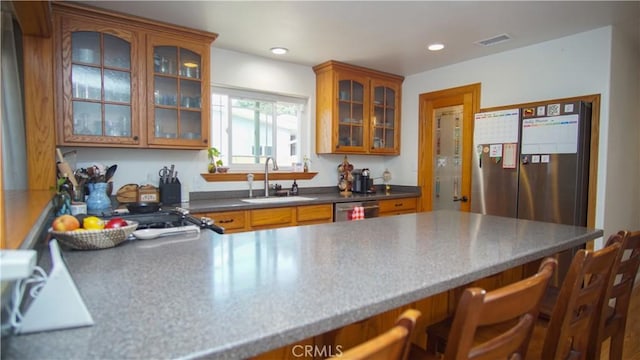 412 N Mallagh St, Nipomo, CA 93444 - kitchen with brown cabinetry, a kitchen breakfast bar, glass insert cabinets, dishwasher, and a peninsula