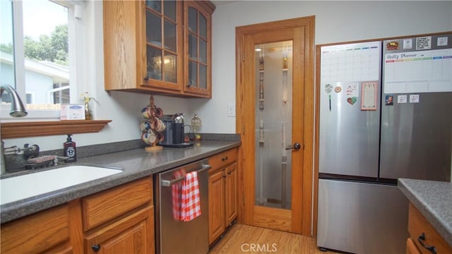 412 N Mallagh St, Nipomo, CA 93444 - kitchen with stainless steel appliances, brown cabinetry, glass insert cabinets, light wood-style flooring, and dark countertops