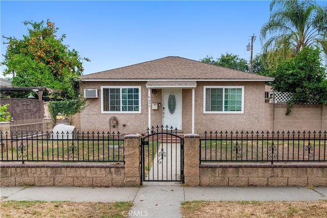 9430 Mines Ave, Pico Rivera, CA 90660 - bungalow-style house featuring stucco siding, a fenced front yard, a shingled roof, a wall unit AC, and a gate