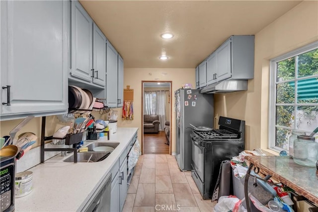 9430 Mines Ave, Pico Rivera, CA 90660 - kitchen featuring black gas range, under cabinet range hood, light countertops, freestanding refrigerator, and recessed lighting