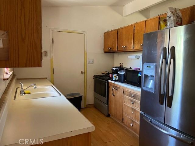 7 Westwood Way, Oroville, CA 95966 - kitchen featuring appliances with stainless steel finishes, brown cabinets, light wood-style flooring, light countertops, and lofted ceiling