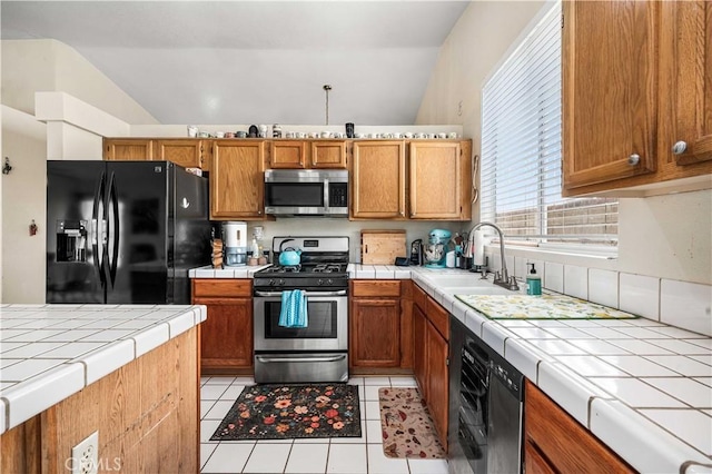 3038 Kaylyn St, Lancaster, CA 93535 - kitchen with stainless steel appliances, tile countertops, lofted ceiling, light tile patterned flooring, and brown cabinets