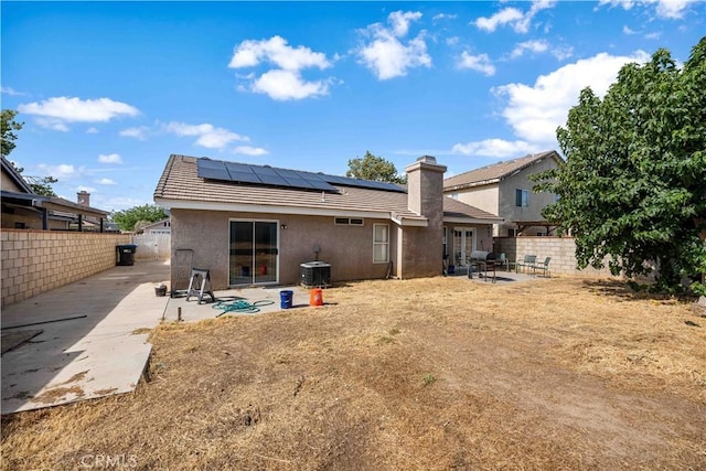 3038 Kaylyn St, Lancaster, CA 93535 - rear view of house featuring a patio, solar panels, a fenced backyard, a chimney, and stucco siding