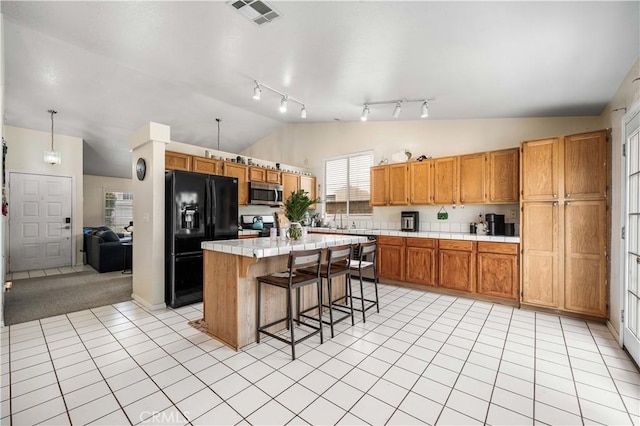3038 Kaylyn St, Lancaster, CA 93535 - kitchen with stainless steel appliances, lofted ceiling, a kitchen breakfast bar, a kitchen island, and tile countertops