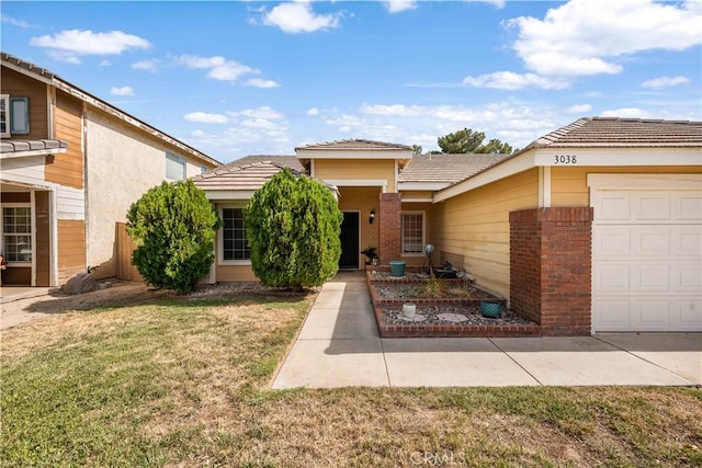 3038 Kaylyn St, Lancaster, CA 93535 - view of front facade featuring a garage, a front yard, and brick siding