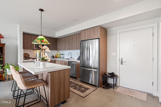 482 S Arroyo Pkwy Unit 405, Pasadena, CA 91105 - kitchen with stainless steel appliances, light countertops, a breakfast bar, finished concrete flooring, and hanging light fixtures