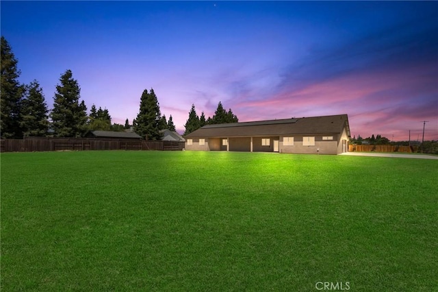 1021 Prince William Ct, Atwater, CA 95301 - back of property at dusk featuring a fenced backyard, roof mounted solar panels, and concrete driveway