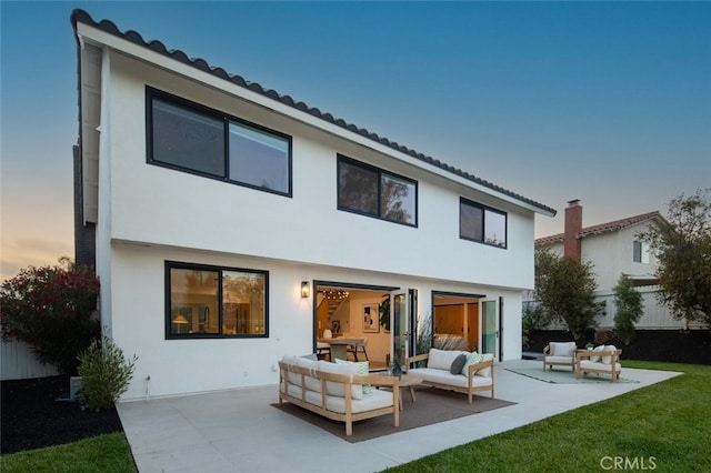 25302 Posada Ln, Mission Viejo, CA 92691 - back of property at dusk featuring an outdoor living space, a patio, stucco siding, and a tile roof