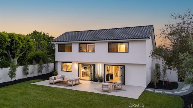 25302 Posada Ln, Mission Viejo, CA 92691 - back of property at dusk featuring stucco siding, outdoor lounge area, a tiled roof, and a patio