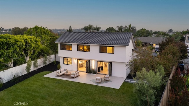 25302 Posada Ln, Mission Viejo, CA 92691 - back of house at dusk with an outdoor living space, a tiled roof, stucco siding, a fenced backyard, and a patio area