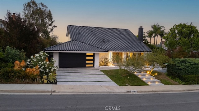 25302 Posada Ln, Mission Viejo, CA 92691 - view of front facade featuring a tiled roof, a garage, stucco siding, driveway, and a chimney