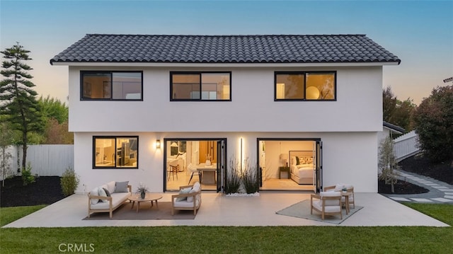 25302 Posada Ln, Mission Viejo, CA 92691 - back of house at dusk featuring stucco siding, a patio area, outdoor lounge area, and a tile roof