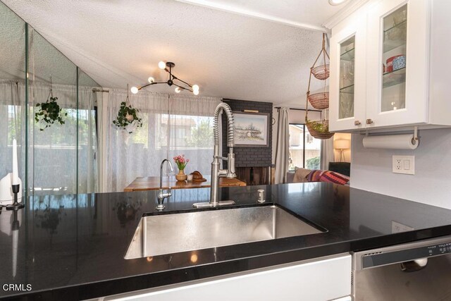 15050 Sherman Way Unit 189, Van Nuys, CA 91405 - kitchen featuring stainless steel dishwasher, dark countertops, plenty of natural light, white cabinetry, and lofted ceiling