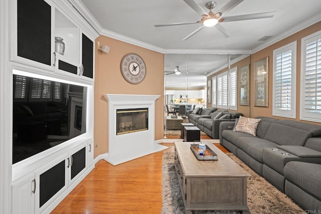 5191 Cobalt Way, Oceanside, CA 92057 - living area with ceiling fan, crown molding, light wood-style flooring, and a glass covered fireplace
