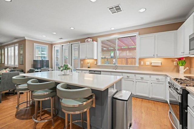 5191 Cobalt Way, Oceanside, CA 92057 - kitchen with appliances with stainless steel finishes, crown molding, a center island, white cabinets, and recessed lighting