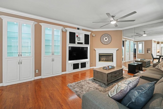 5191 Cobalt Way, Oceanside, CA 92057 - living area with ceiling fan, wood finished floors, ornamental molding, and a glass covered fireplace