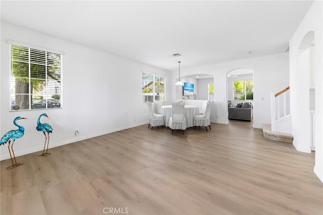15216 Masline St, Baldwin Park, CA 91706 - dining room with arched walkways, light wood-style flooring, and stairway